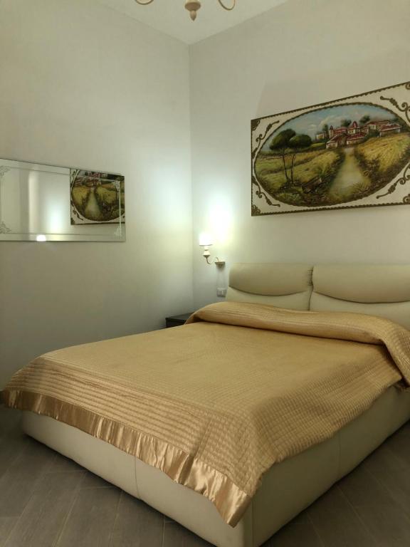 1 dormitorio con 1 cama y una pintura en la pared en casa ginevra en Porto Cesareo
