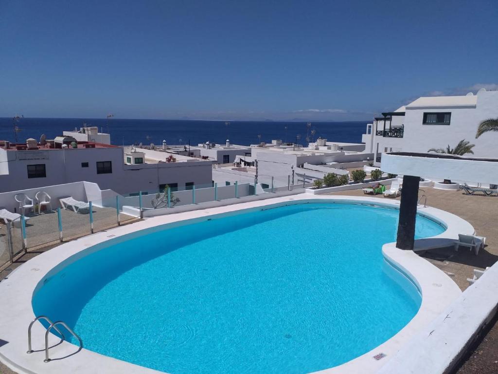 a large blue swimming pool on top of a building at Apartment Portonovo Galit - Sea view - Piscina - Wifi - Old Town in Puerto del Carmen