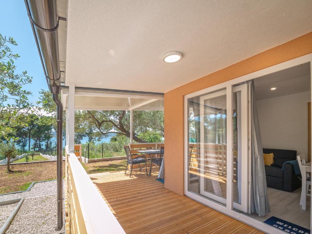 ein Haus mit einer Terrasse mit Blick auf den Hof in der Unterkunft Mobile House Fantina in Sveti Filip i Jakov