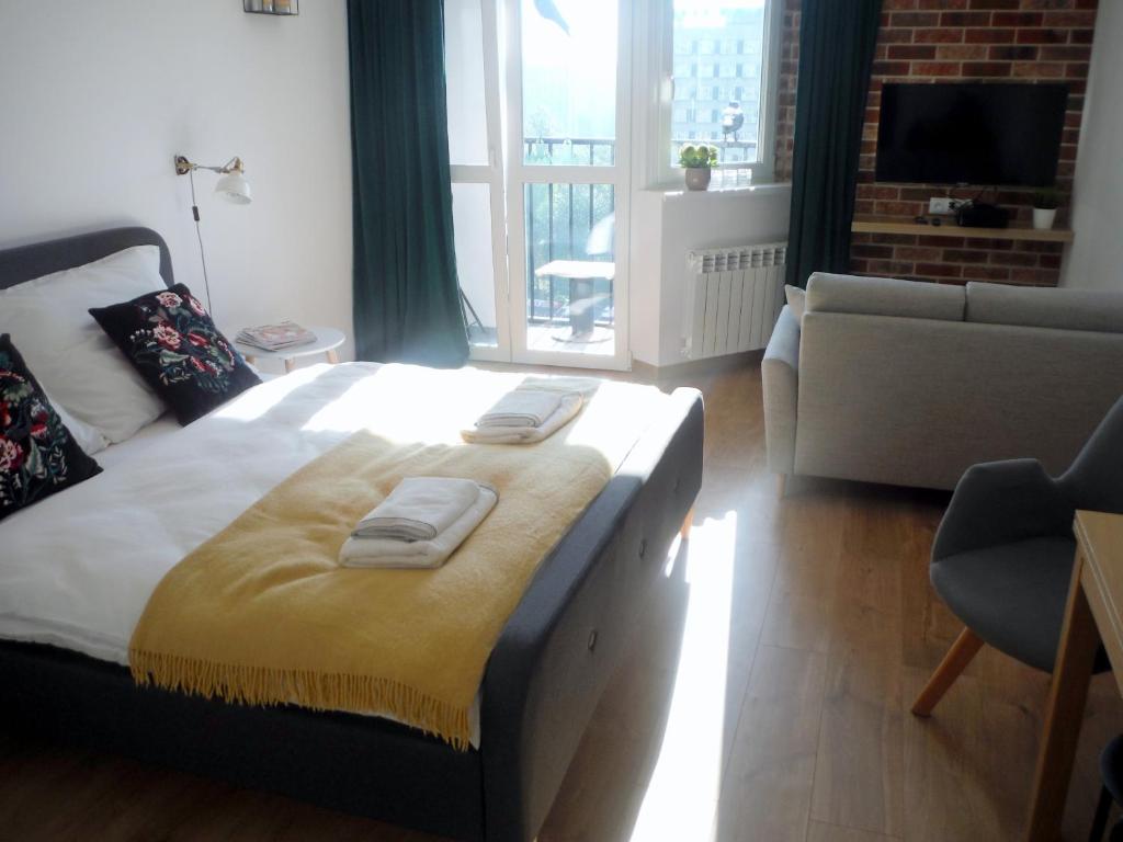 una camera da letto con un letto e due asciugamani di KATO BEST POINT a Katowice