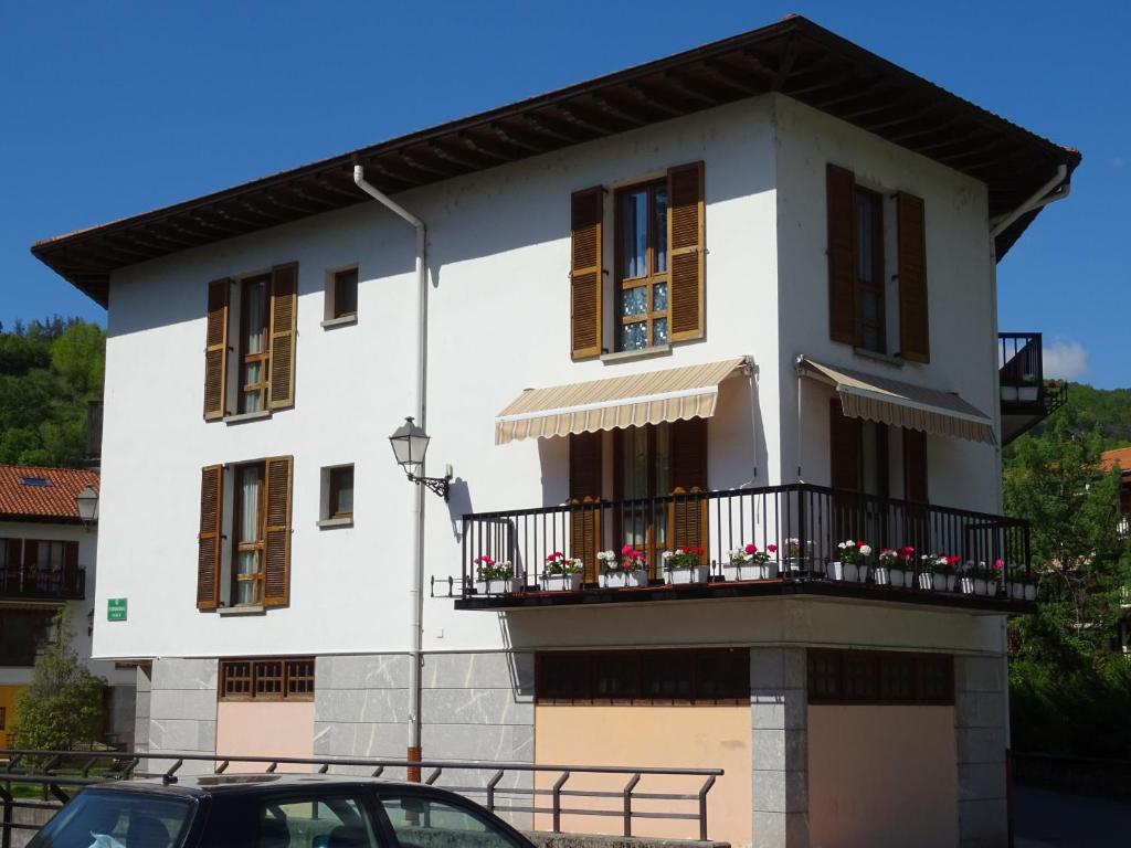 Casa blanca con balcón y coche en Duplex Frain, en Lesaka