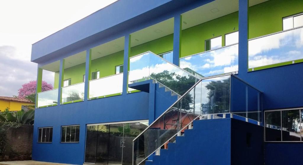 un bâtiment bleu et vert avec un escalier dans l'établissement Pousada das Cachoeiras, à Alto Paraíso de Goiás