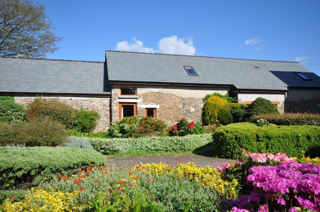 a garden in front of a house with flowers at Montgomery Barn in Bideford