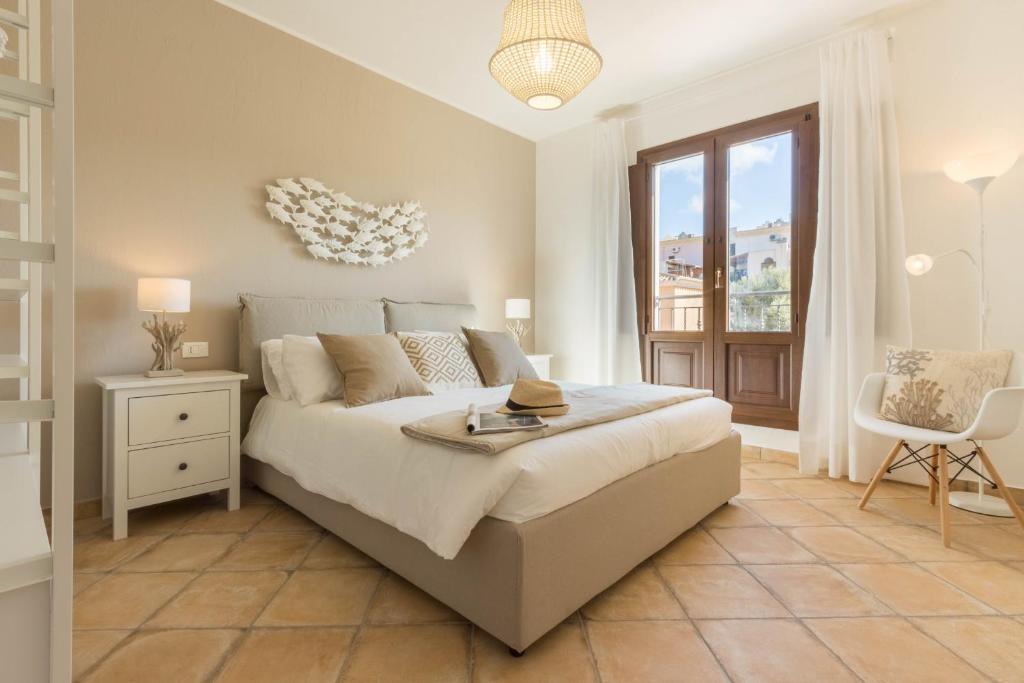 ein Schlafzimmer mit einem großen Bett und einem Fenster in der Unterkunft Villa Amelia in Villasimius