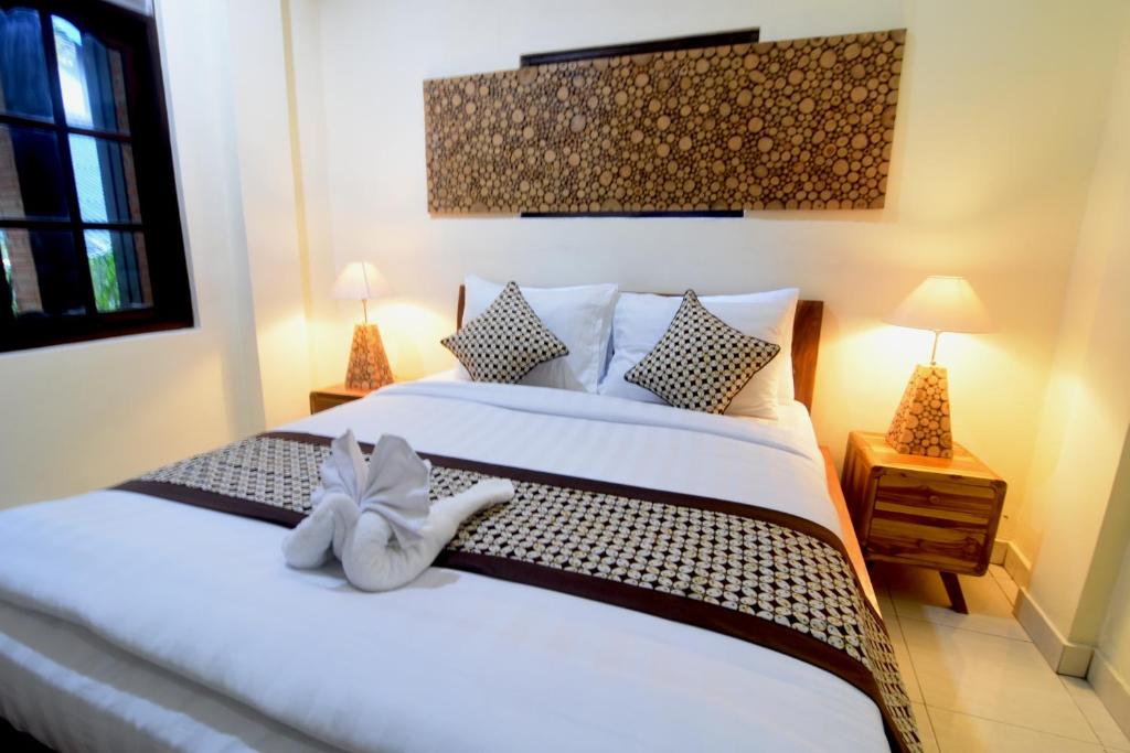 um quarto com uma cama com um bicho de pelúcia em Arik's Homestay Ubud em Ubud