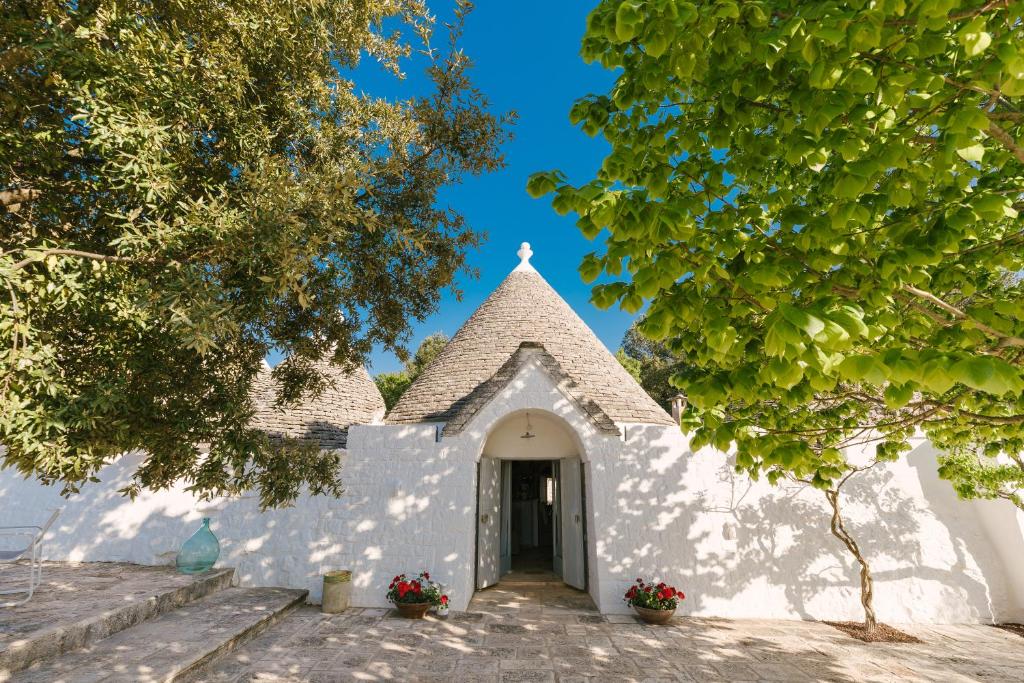 a small white church with a doorway and trees at Charming Trullo with Private Pool and Spa - Trullo Amarcord in Selva di Fasano