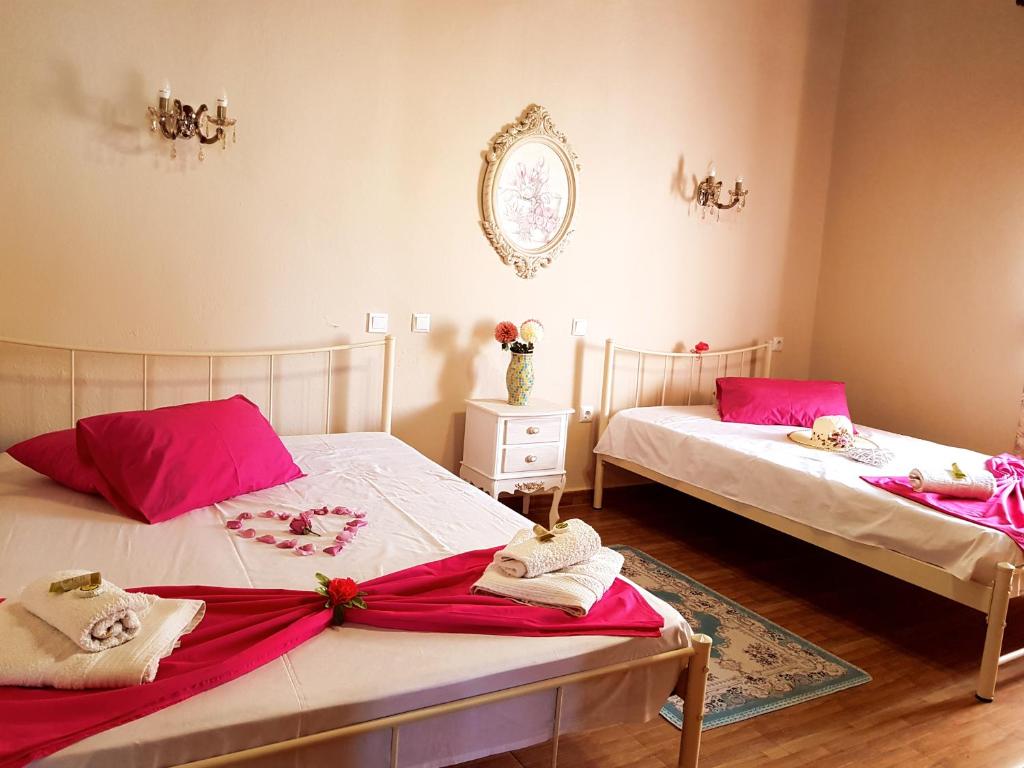two beds in a room with pink towels on them at Dimitra's Garden Villa in Kallirakhi