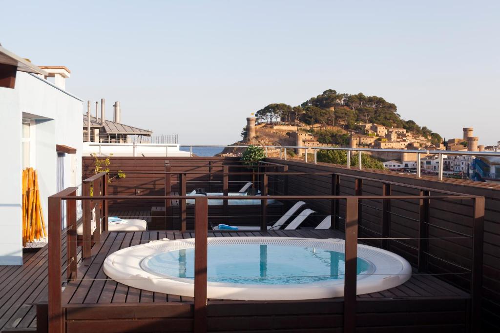 un patio con bañera de hidromasaje en la parte superior de un edificio en Florida, en Tossa de Mar