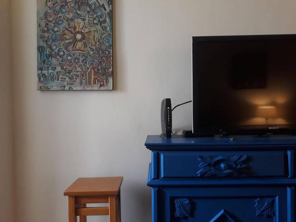 una cómoda azul con un televisor encima en Studio em Botafogo, en Río de Janeiro