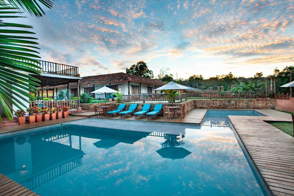 una piscina con tumbonas azules y una casa en Hotel Boutique Venturi, en Barichara