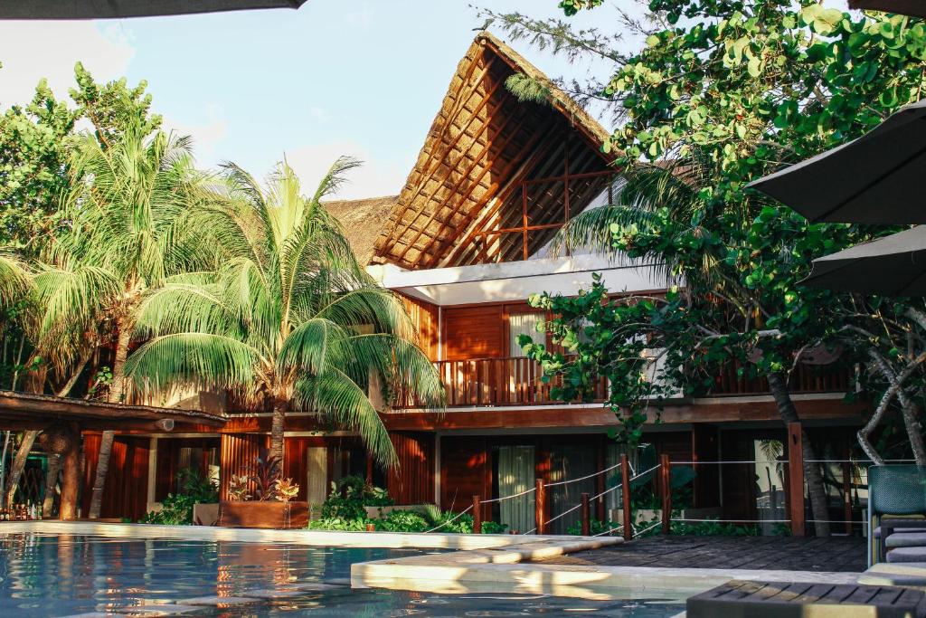 un complejo con piscina frente a un edificio en Villas Caracol, en Isla Holbox