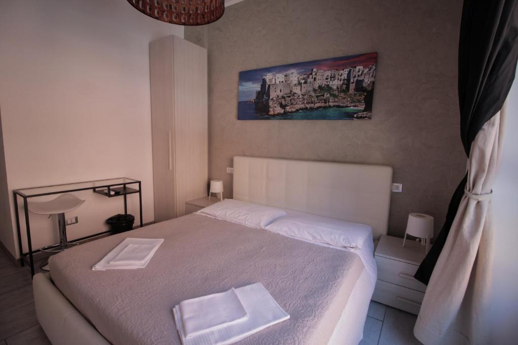 een slaapkamer met een bed met twee witte handdoeken erop bij La Suite Rooms & Apartments in Bologna