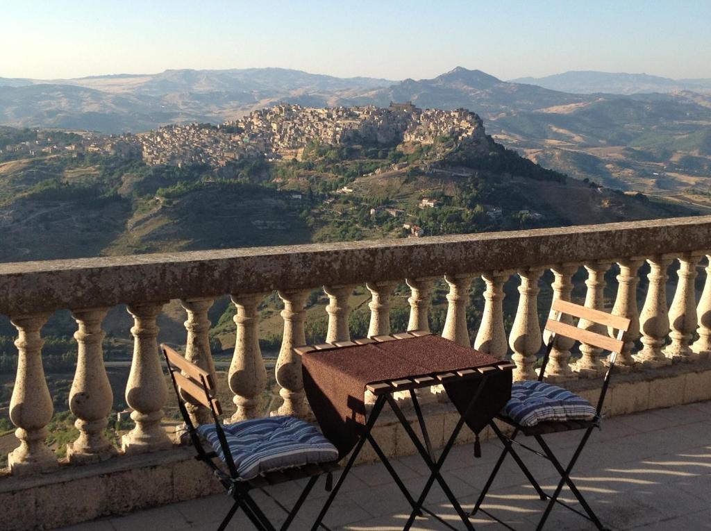 een tafel en stoelen op een balkon met uitzicht bij Enna Inn Centro in Enna