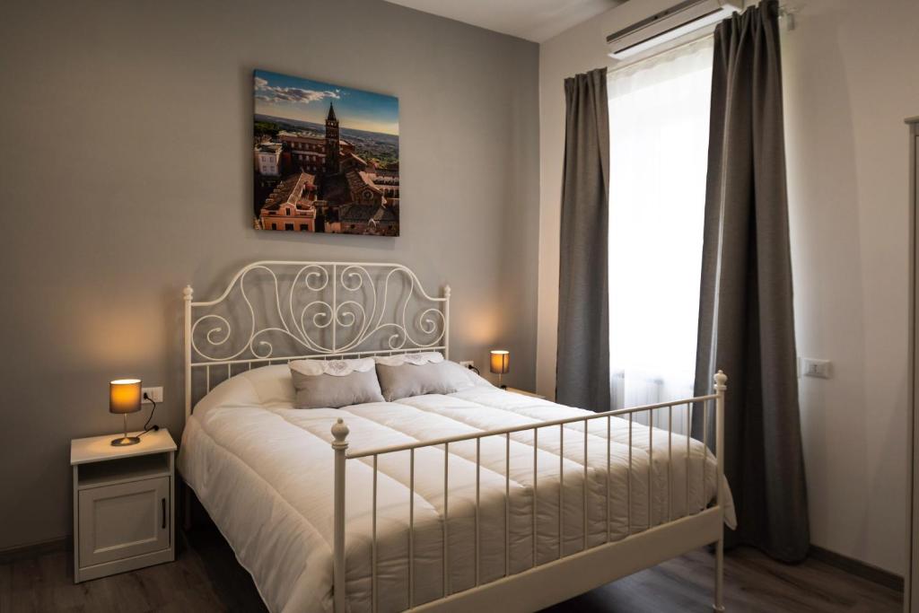 a bedroom with a white bed and a window at Da Ghighì in Tivoli