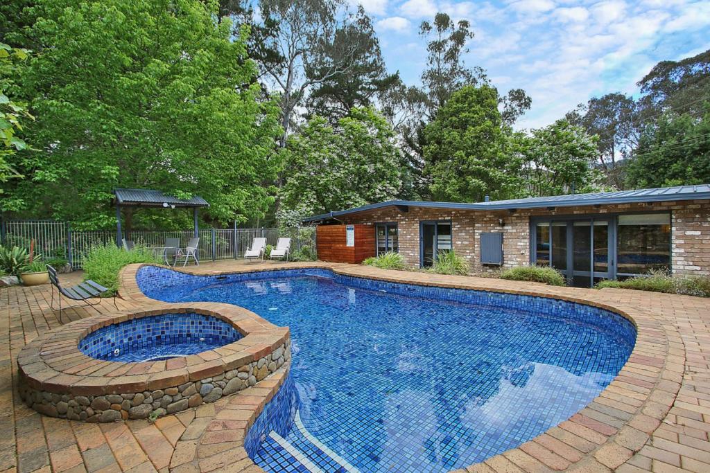 a swimming pool in a yard next to a house at Bright River Rest in Bright