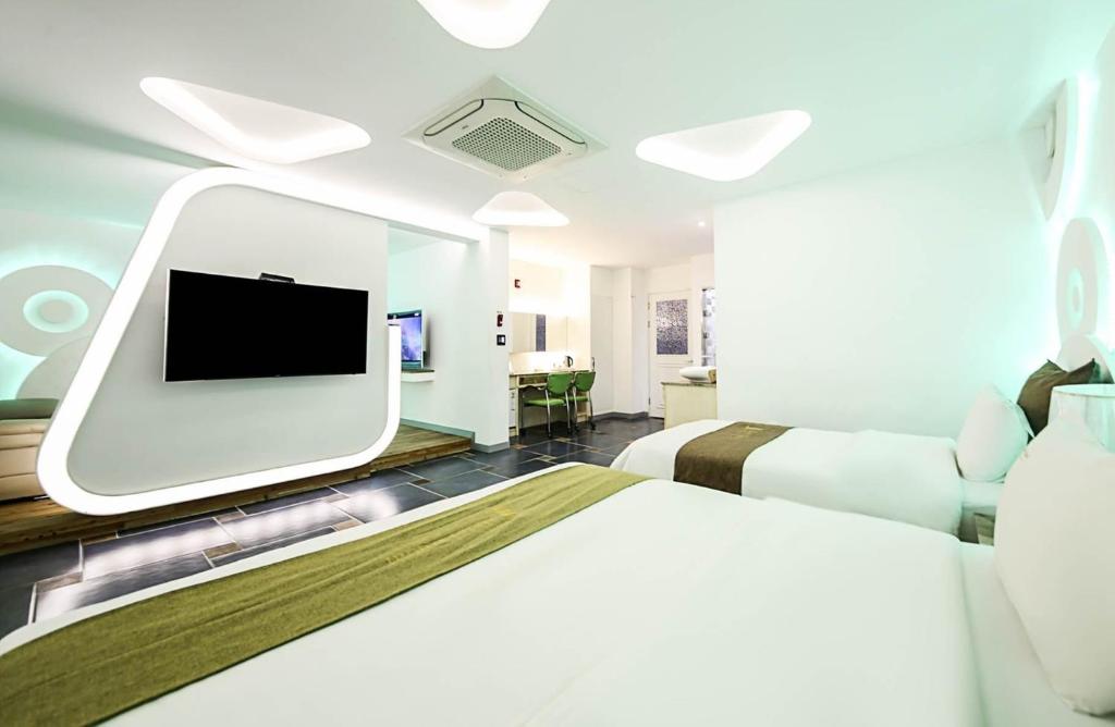 Habitación hospitalaria con 2 camas y TV en Dubai Hotel, en Cheongju