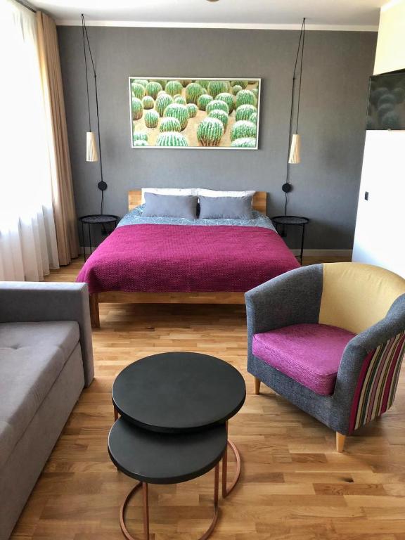 a bedroom with a bed and a couch and a table at Kaktuss apartamenti Smiltene in Smiltene