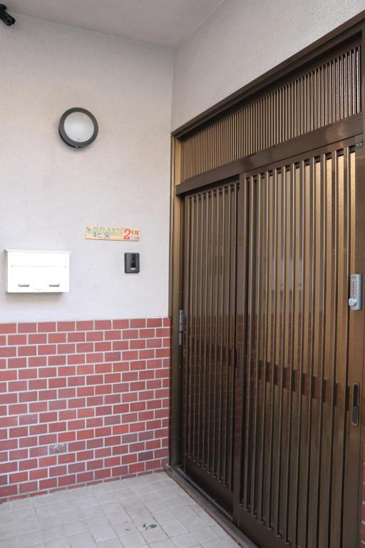 泉佐野市にあるKIX House 和楽二号館の壁に2つのドアと時計が付いた部屋
