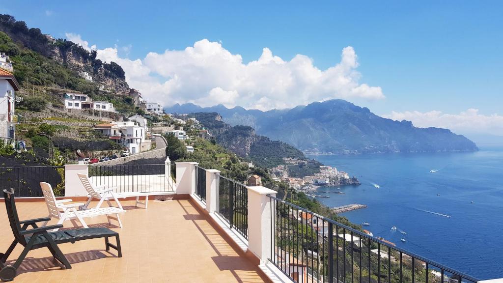 a balcony with two chairs and a view of the ocean at Amalfi Hills in Amalfi