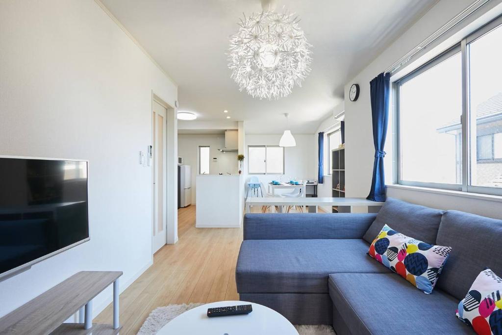 ein Wohnzimmer mit einem blauen Sofa und einem Tisch in der Unterkunft koiwa house 3LDK free wifi free parking in Tokio