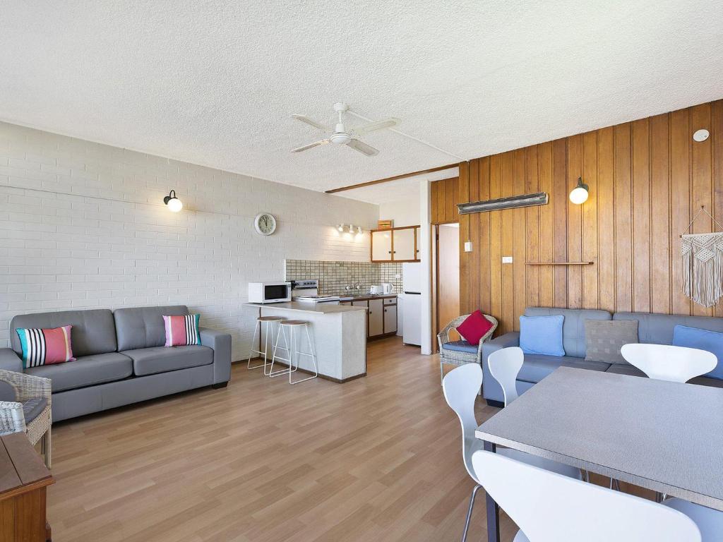 ein Wohnzimmer mit einem Sofa und einem Tisch in der Unterkunft The Sands Apartment 6 in The Entrance