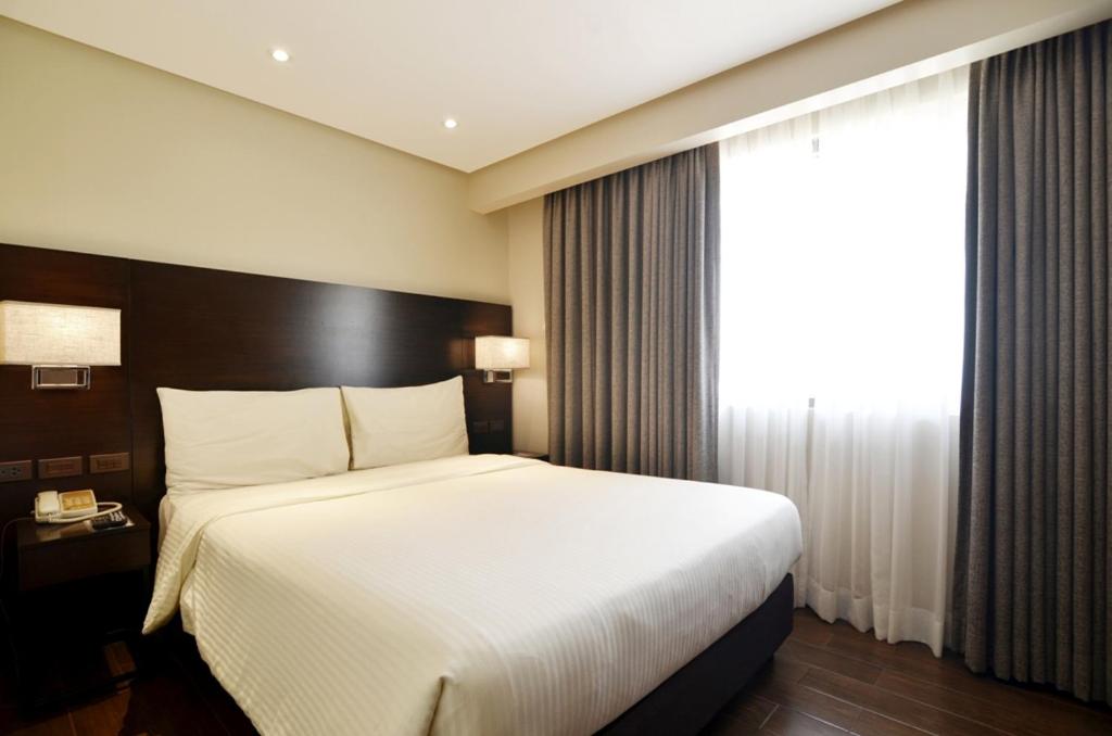 Postel nebo postele na pokoji v ubytování Pearl Garden Hotel