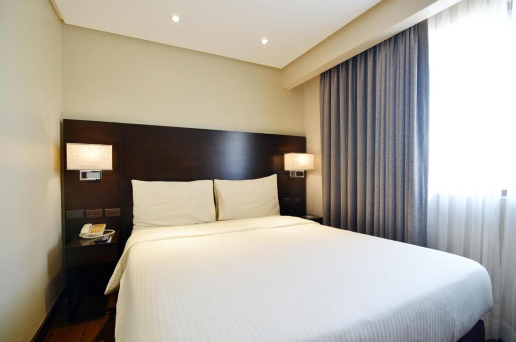 Postel nebo postele na pokoji v ubytování Pearl Garden Hotel