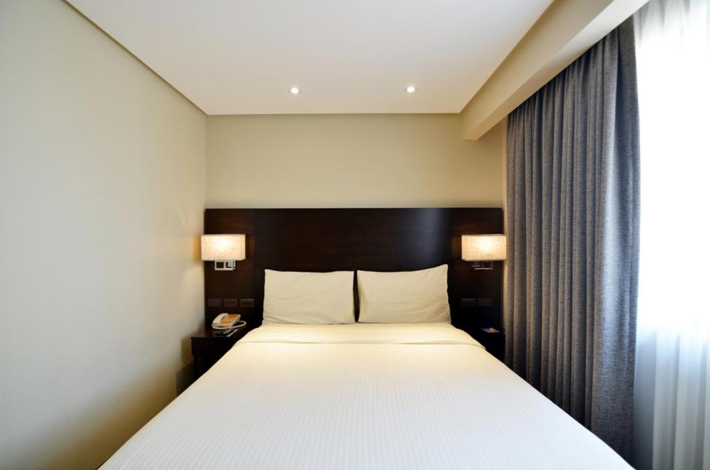 Postel nebo postele na pokoji v ubytování Pearl Garden Hotel
