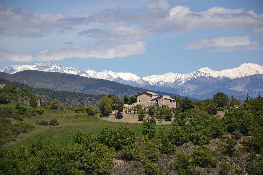 a house on a hill with snowy mountains in the background at Le Vieil Aiglun in Aiglun
