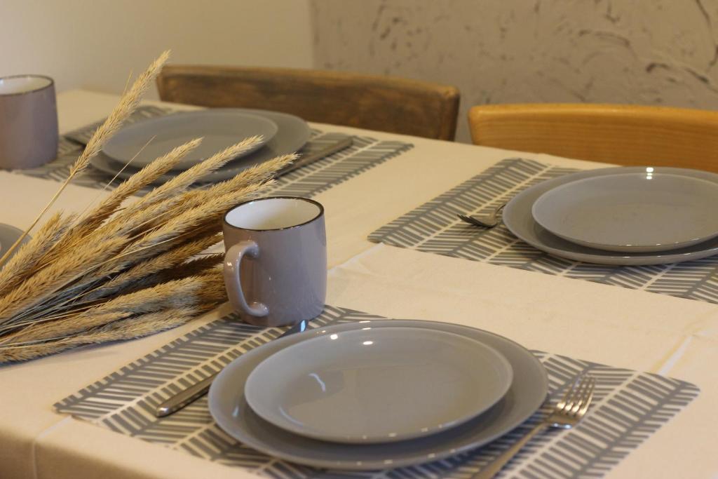 a table with plates and utensils on a table at Pušelė in Nida