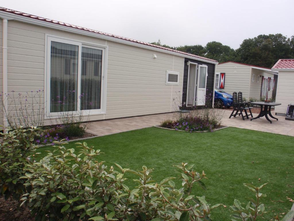 einen Hof mit einem Haus und einem Picknicktisch in der Unterkunft Meerchalets in Biggekerke