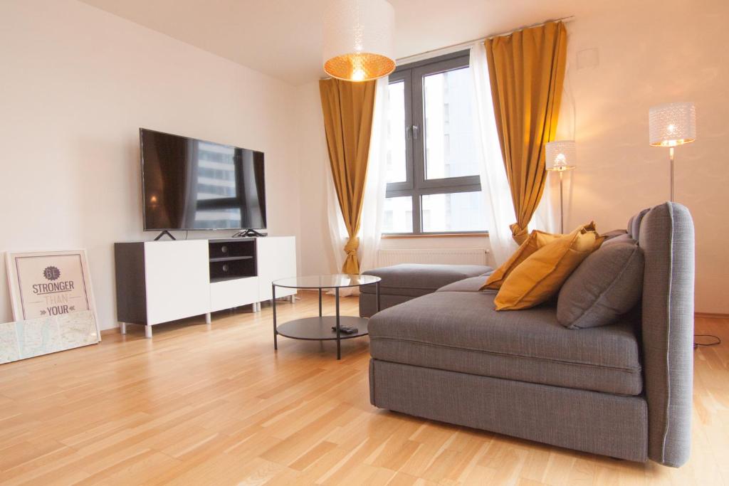 a living room with a couch and a television at Apollo Apartment - Key-Box - Free Parking in Bratislava