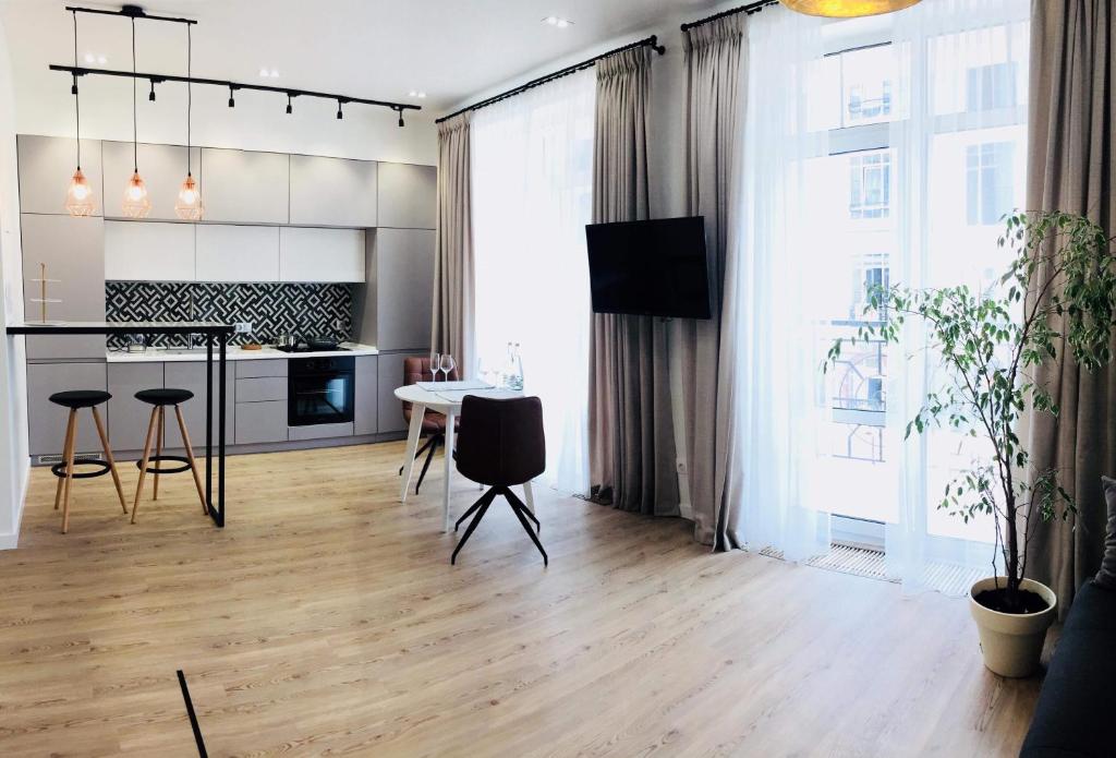 cocina y sala de estar con mesa y sillas en MODERN LUXURY Apartment in the heart of Kiev en Kiev