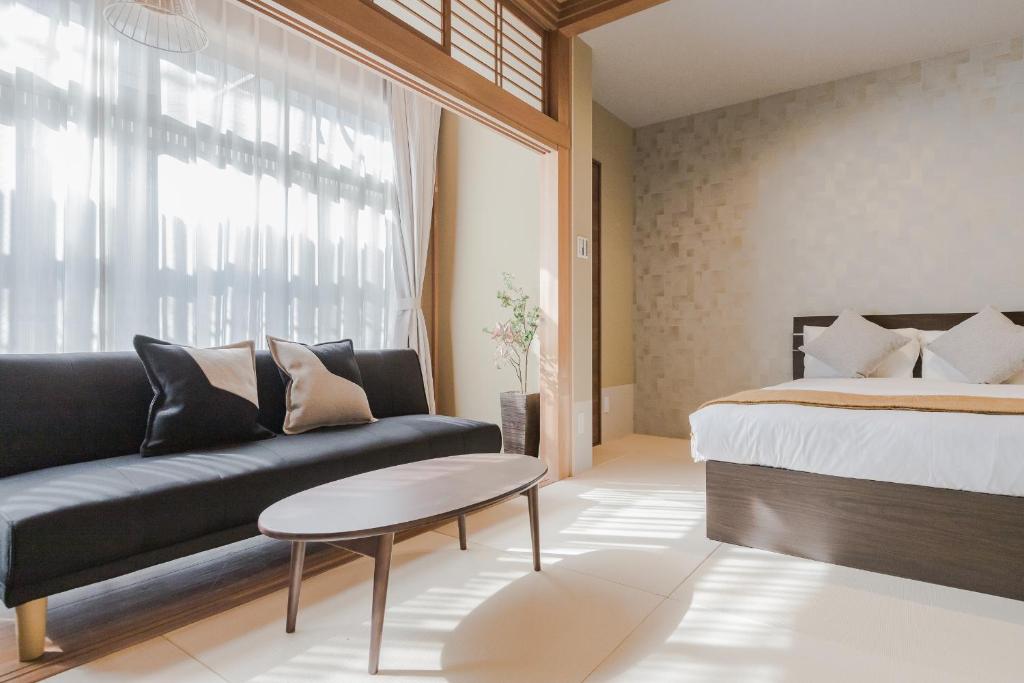 東京的住宿－PLAYSIS Asakusa，一间卧室配有一张床、一张沙发和一张桌子