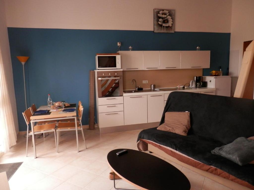 a living room with a couch and a table and a kitchen at residence Mare Turchinu in Monticello