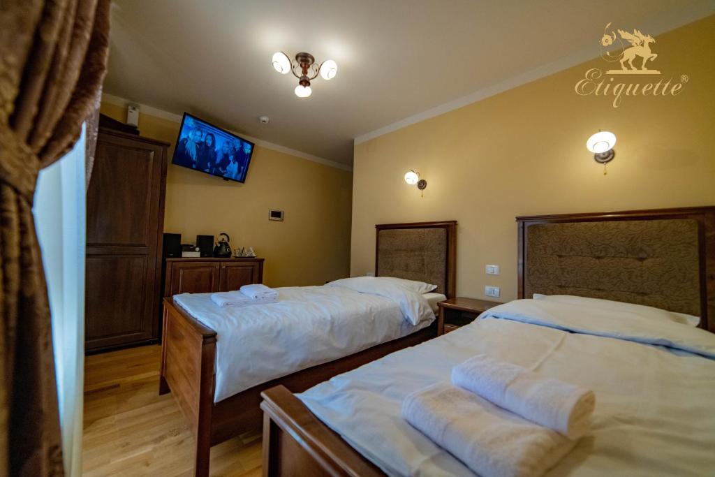 a bedroom with two beds and a flat screen tv at Villa Etiquette in Deva