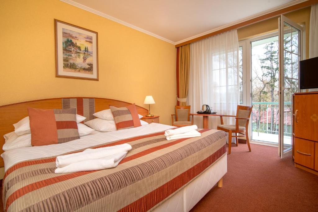 Pokój hotelowy z łóżkiem i balkonem w obiekcie Hotel Spa Hévíz w Hévízie