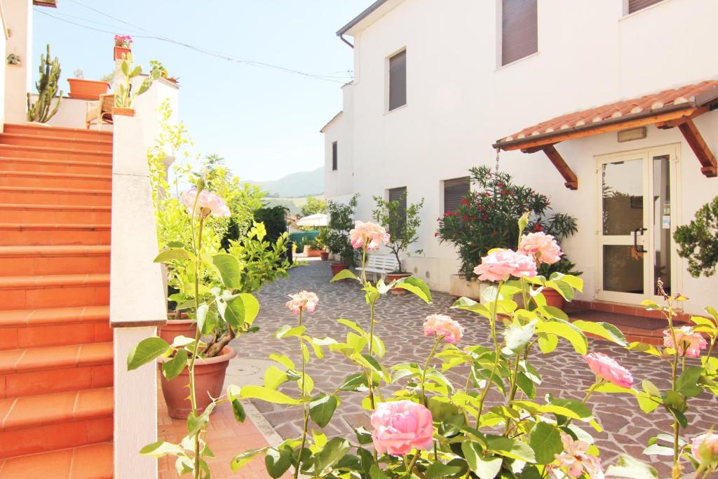 a garden with pink roses in front of a house at Hotel Boni Cerri in Spoleto