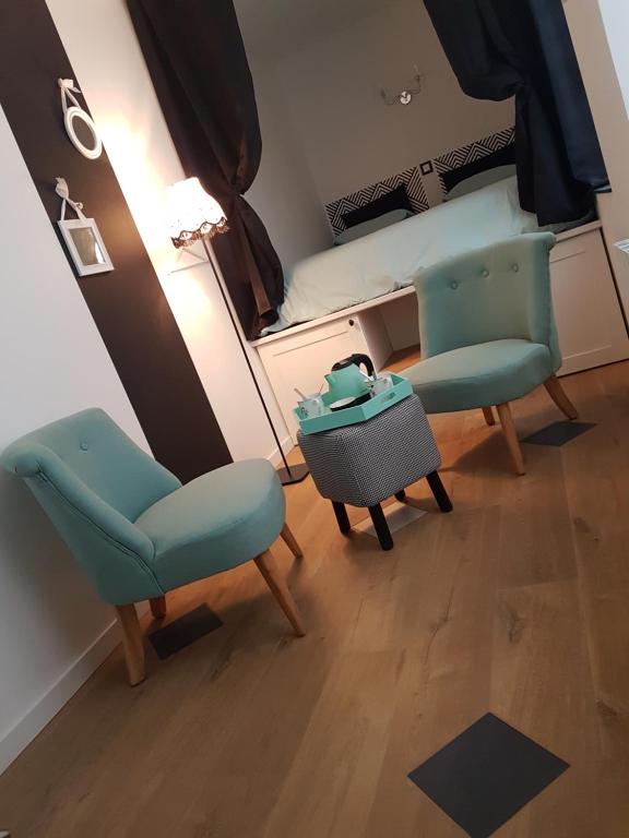 a room with two chairs and a bed with a mirror at La Bonbonnière de Salomé Hyper centre parking possible in Rouen