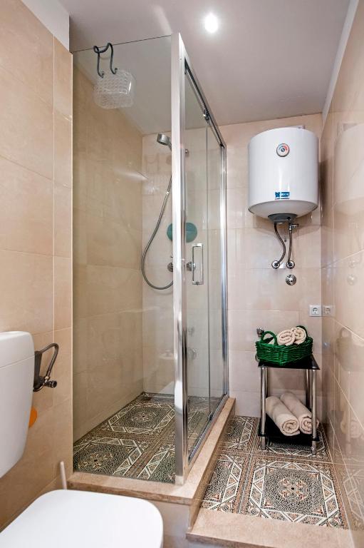 prysznic ze szklanymi drzwiami w łazience w obiekcie Apartman Delfin w Rovinj
