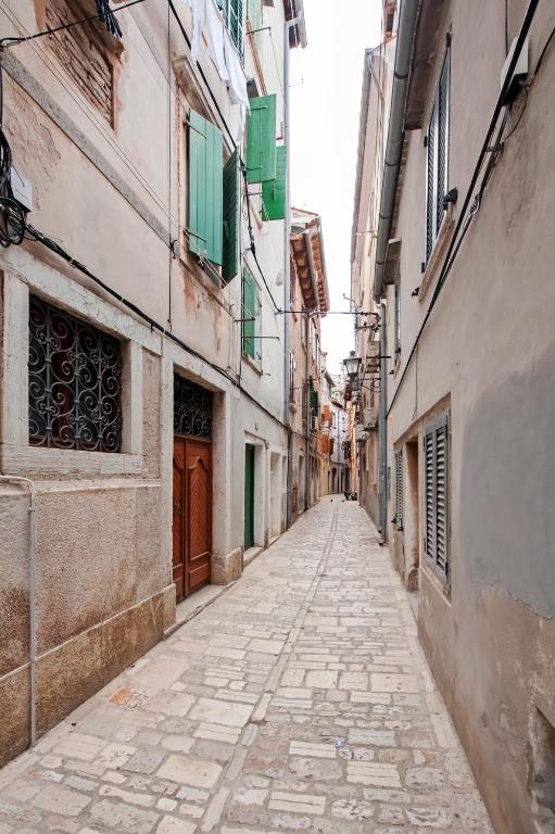pusta ulica w alejce pomiędzy dwoma budynkami w obiekcie Apartman Delfin w Rovinj