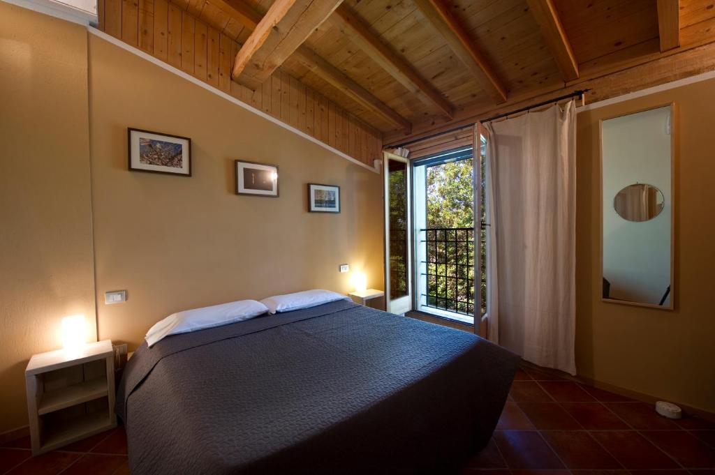 sypialnia z dużym łóżkiem i dużym oknem w obiekcie Borgo San Donino w mieście Desenzano del Garda
