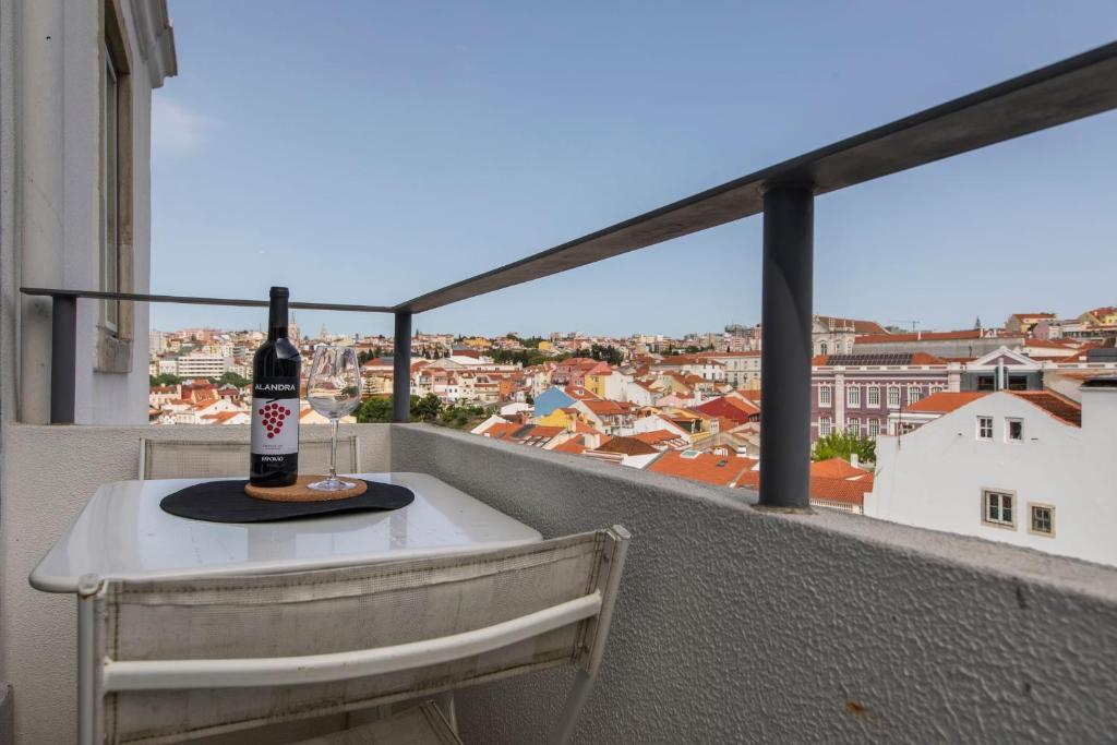 uma garrafa de vinho numa mesa na varanda em LovelyStay - Sunny Santa Catarina I em Lisboa