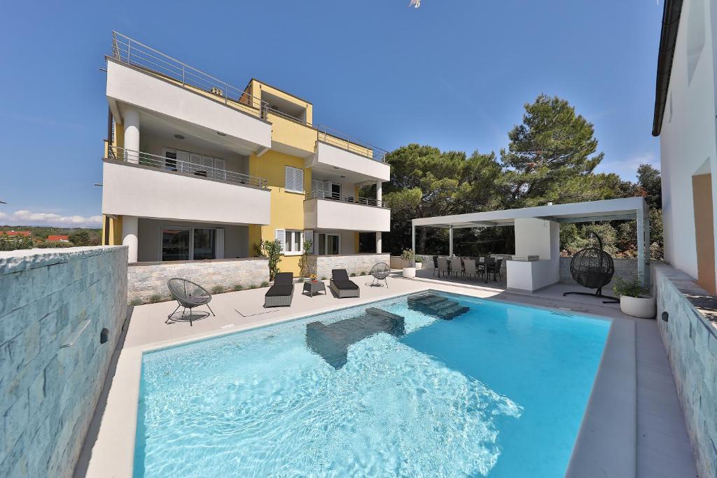 a swimming pool in front of a house at Luxury Villa Nada with Pool in Petrcane