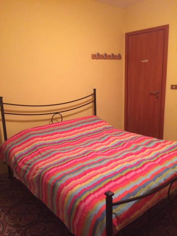 łóżko z kolorową kołdrą w pasku w sypialni w obiekcie Sotto i coppi w mieście Refrancore