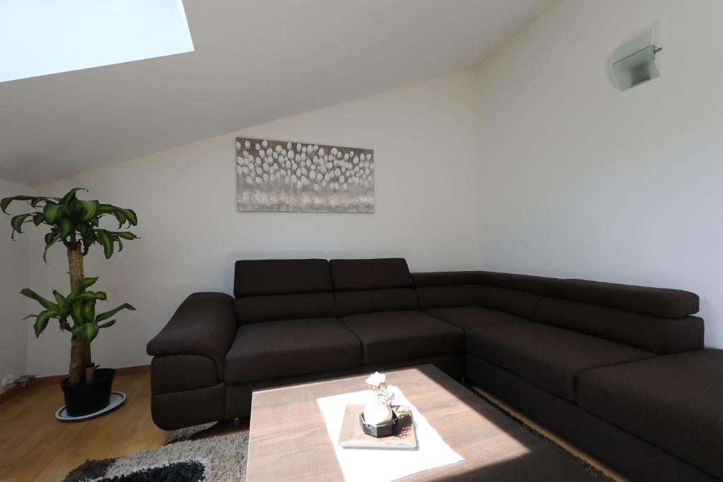 a living room with a black couch and a table at Luxury Villa Nada with Pool in Petrcane