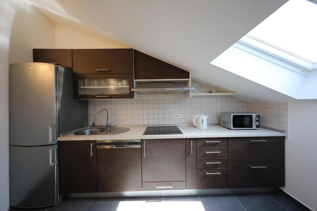 a kitchen with brown cabinets and a refrigerator at Luxury Villa Nada with Pool in Petrcane