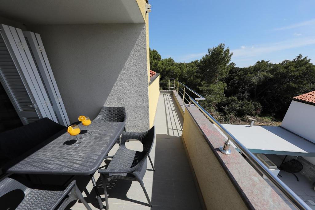 a balcony with a table and chairs on a building at Luxury Villa Nada with Pool in Petrcane
