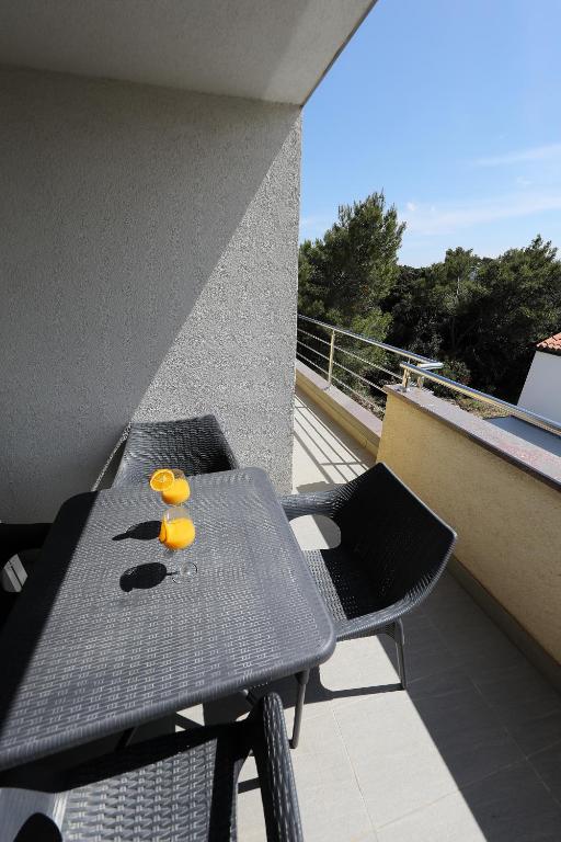 a table and chairs on the balcony of a building at Luxury Villa Nada with Pool in Petrcane