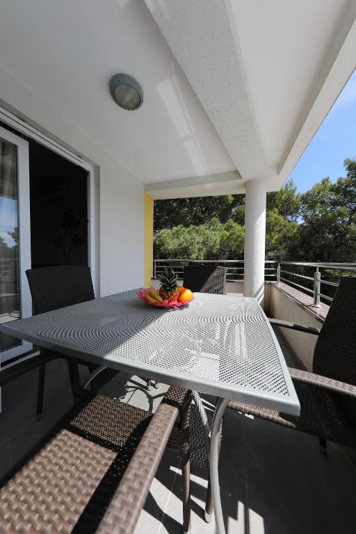 a table and chairs on a balcony with a view at Luxury Villa Nada with Pool in Petrcane